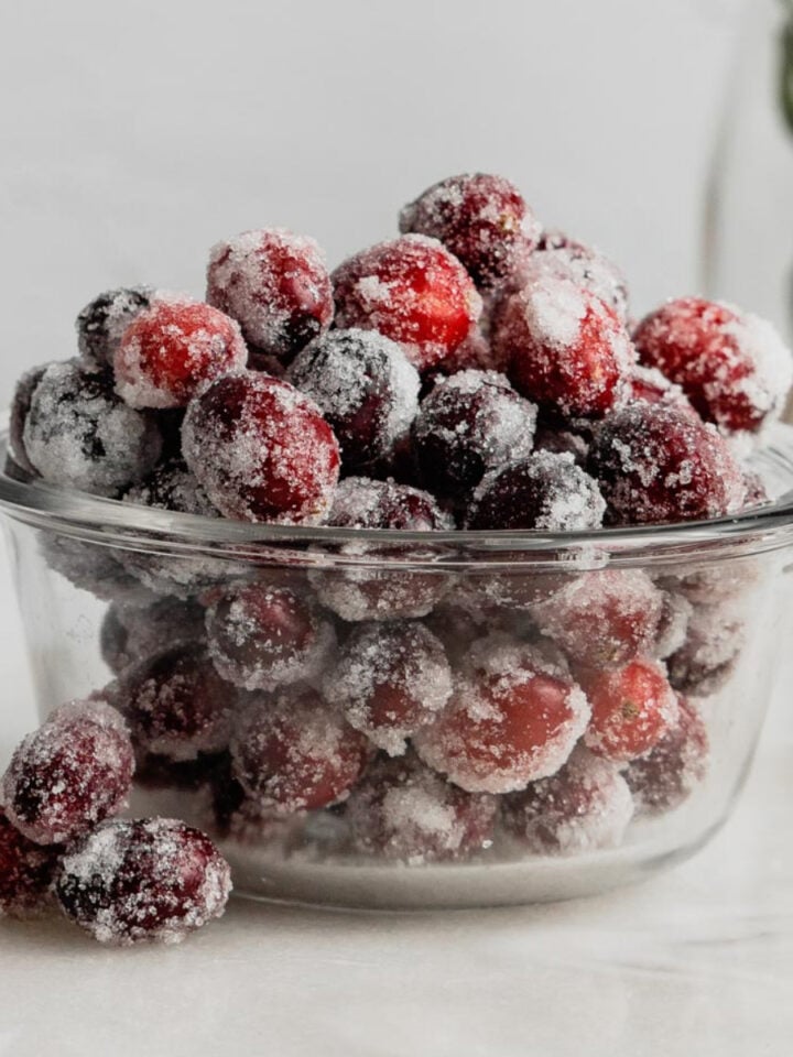 A small glass bowl filled with sugared cranberries.