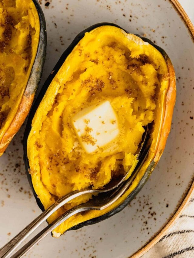 Half a microwaved acorn squash with a pat of butter in the center sprinkled with brown sugar.