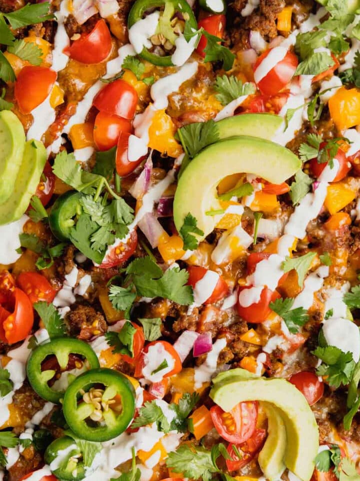 A close up of a pan full of ground venison tater tot nachos.