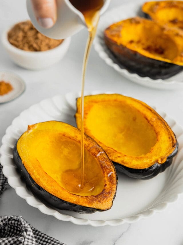 A handle drizzles maple syrup over roasted acorn squash halves.
