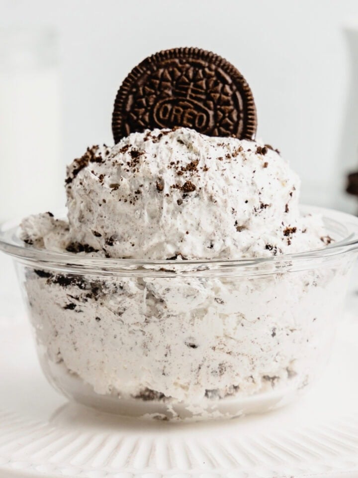 A small glass dish filled with Oreo fluff and garnished with a whole cookie.