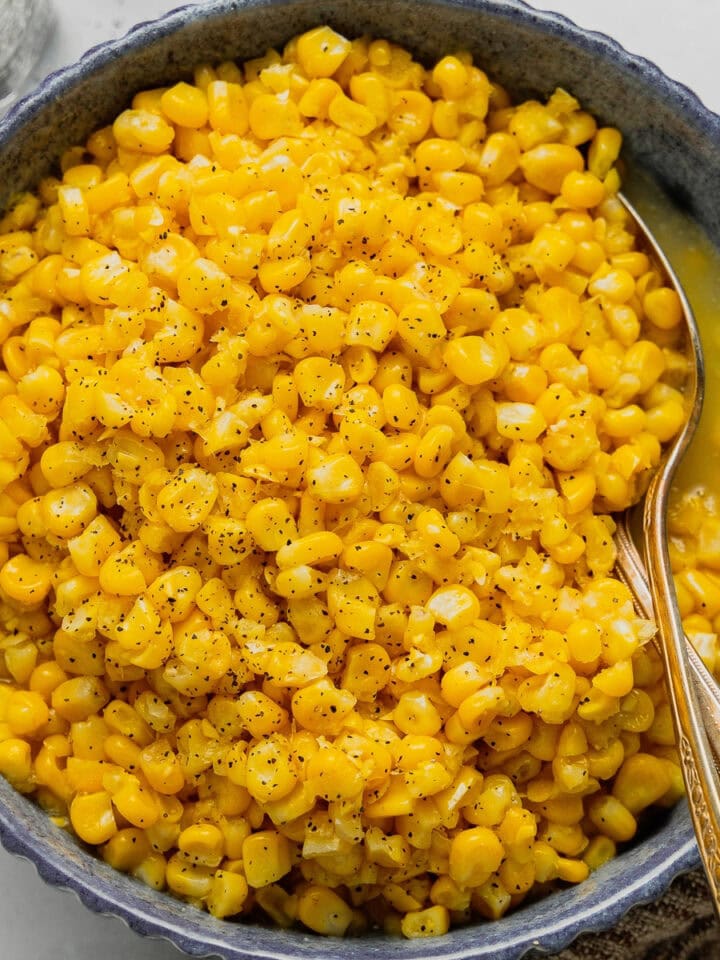 An overhead image of a blue bowl filled with freezer corn.