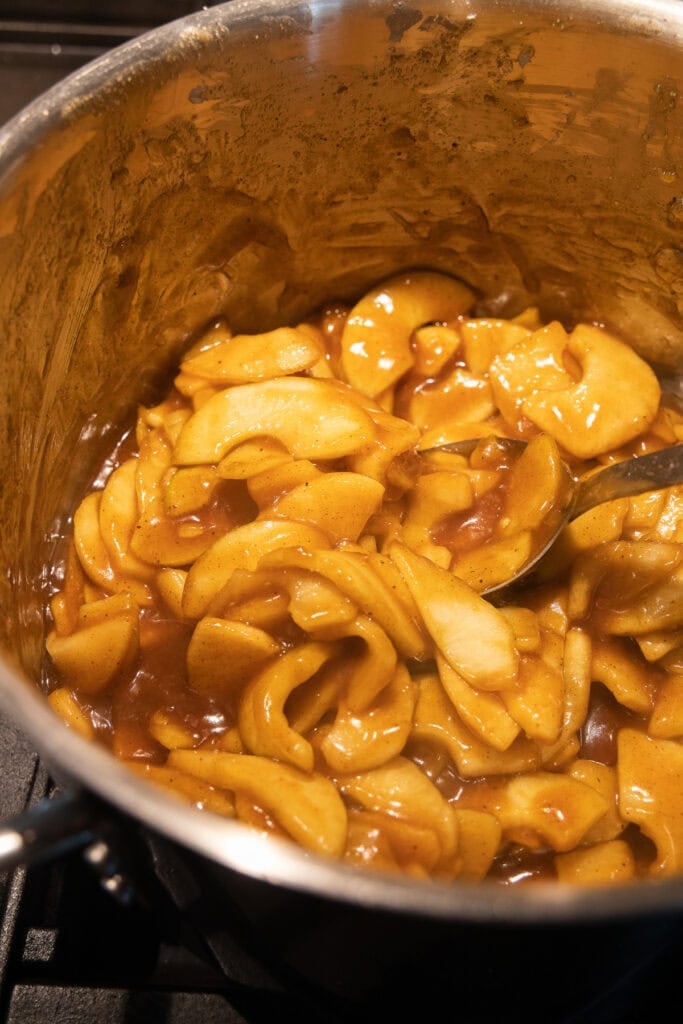 Apple pie filling in a stainless steel stock pot before cooking.