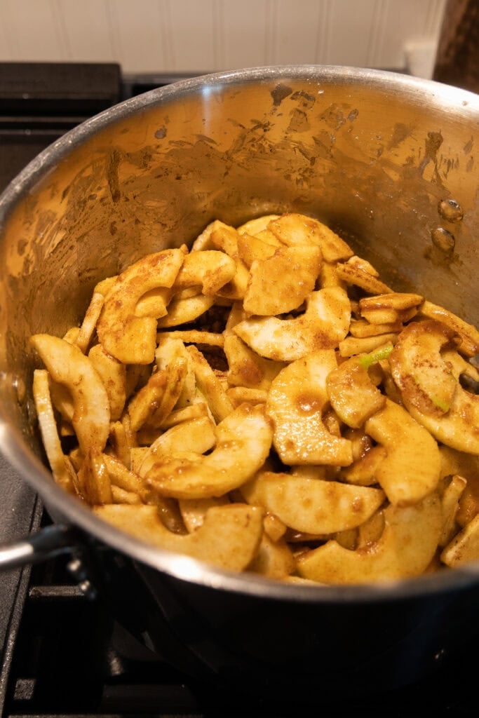 Apple pie filling in a stainless steel stock pot before cooking.